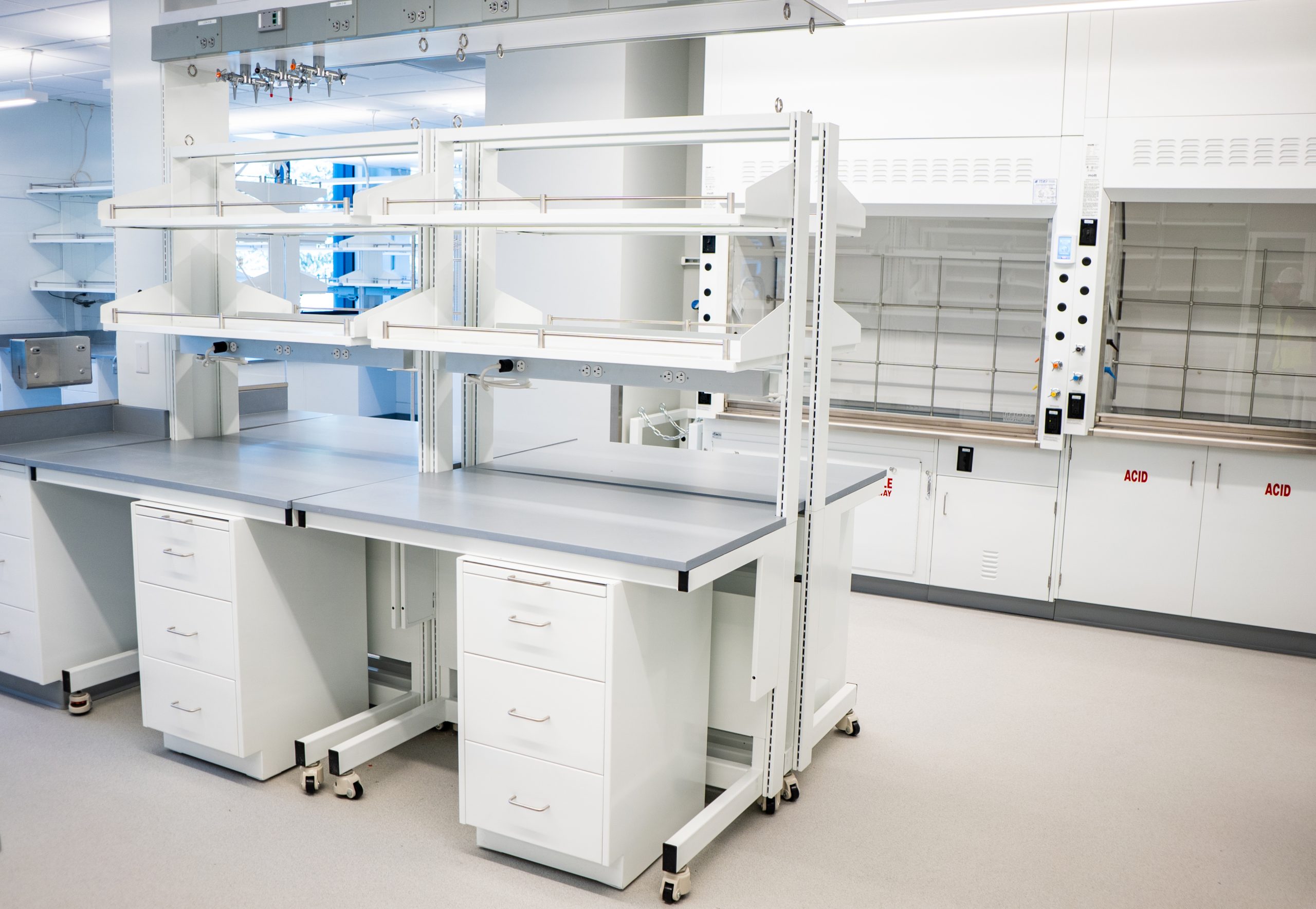 Sigma Carts with cabinets below the worktop, Pro Series fume hoods, in a lab